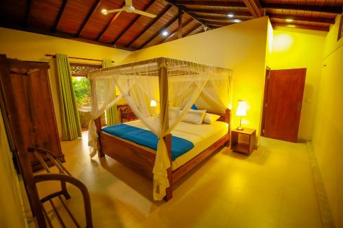 1 dormitorio con cama con dosel en una habitación en Lenora Villas, en Bentota