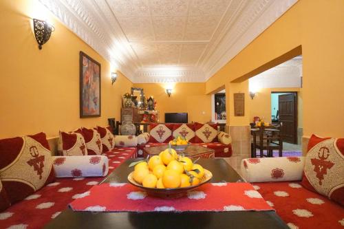 a living room with a bowl of fruit on a table at Riad Dar Rita in Ouarzazate