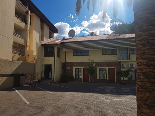 een gebouw met de zon in de lucht erachter bij hotel pension steiner in Windhoek