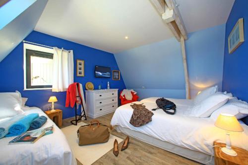 een blauwe slaapkamer met twee bedden en een ladekast bij La Malonie in Sarlat-la-Canéda
