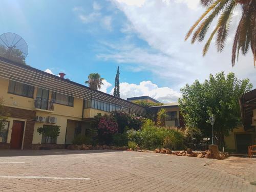 a parking lot in front of a building at Hotel Pension Steiner in Windhoek