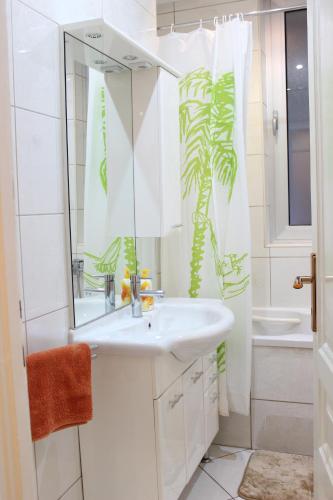 a white bathroom with a sink and a shower at Apartman Buna in Sarajevo