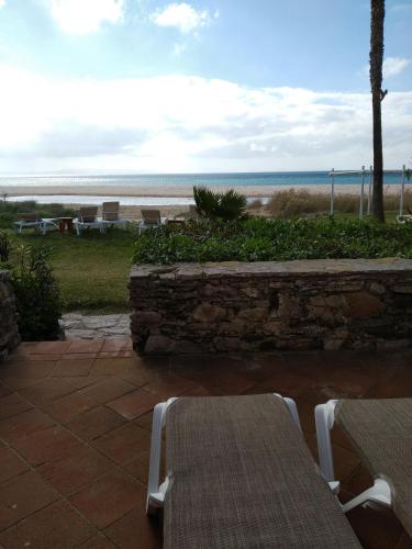 a table and chairs on a patio near the beach at Beach Hotel Dos Mares in Tarifa