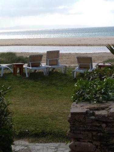 two chairs and a table on the beach at Beach Hotel Dos Mares in Tarifa