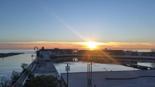 a sunset over a body of water with the sun setting at Michelangelo rta in Cinquale