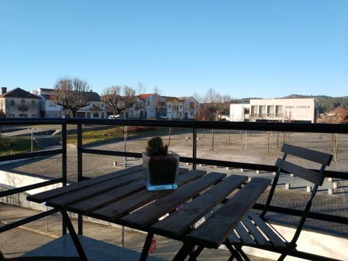 a person sitting on a bench with a laptop at Alto Minho Central Apartment in Paredes de Coura