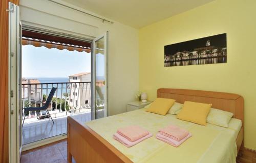 a bedroom with a bed and a balcony with a view at Apartman Marta in Podstrana