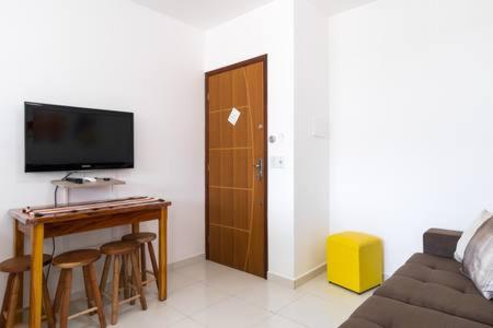 ein Wohnzimmer mit einer Couch und einem Tisch und einem Fernseher in der Unterkunft Praia Ubatuba Apartamento SilBraSil in Ubatuba