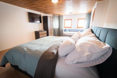 a bedroom with a large bed with pillows at Villa Ďumbierka - B&B, wellness, brewery, ebikes in Mýto pod Ďumbierom