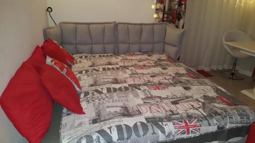 ギジツコにあるApartament Angielski z klimatyzacja przy plaży i porcieのベッドルーム1室(赤い枕のベッド1台付)