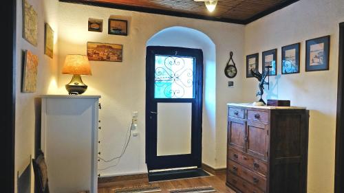 a room with a door and a dresser and a lamp at The old olive mill house in Aegae