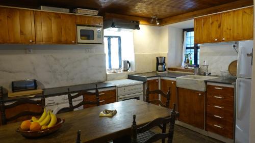 a kitchen with a table with a bowl of fruit on it at The old olive mill house in Aegae