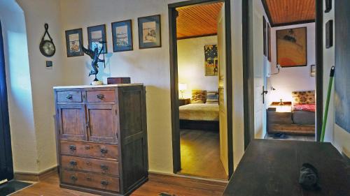 a room with a dresser and a bedroom with a mirror at The old olive mill house in Aegae