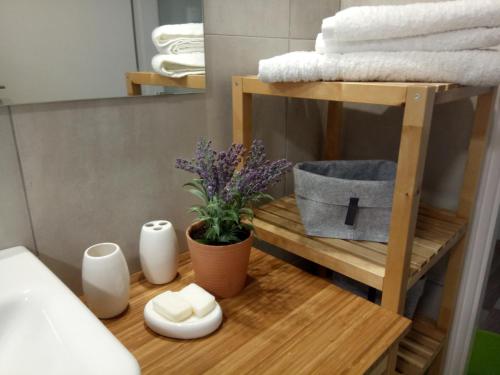baño con una estantería de madera con toallas y una planta en Villa Anastasia, en Kalamaki