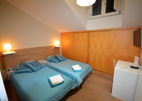 a bedroom with two beds and a desk and a television at B&B Portanova in Salerno