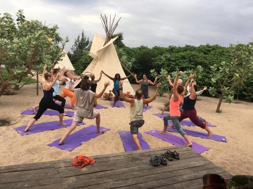 a group of people doing yoga on the beach at Bees Mouth Gambia in Sanyang