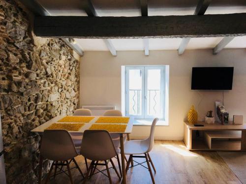 une salle à manger avec une table et des chaises et une fenêtre dans l'établissement Au pied de la Cité, à Carcassonne