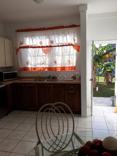 a kitchen with a window and a table with a chair at Personal Touch 1 in Nassau
