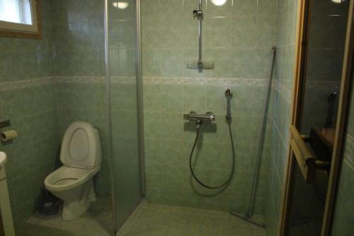 een badkamer met een glazen douche en een toilet bij Kirvesjärven Simpukka in Rokua