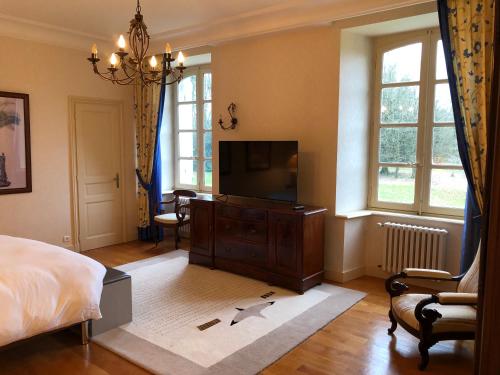 a bedroom with a bed and a flat screen tv at Château de Lannouan in Landévant