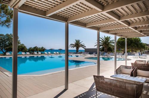 a view of the pool from the patio of a resort at The Bay Hotel & Suites in Vasilikos