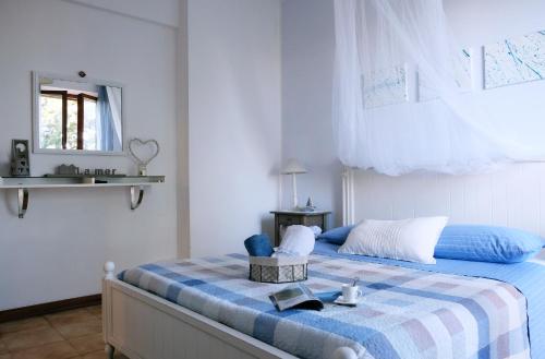 sypialnia z łóżkiem z niebiesko-białym kocem w obiekcie ilmareinmezzo w mieście Porto Recanati