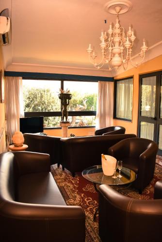 a living room with leather furniture and a chandelier at Hotel Miravalle in Naples