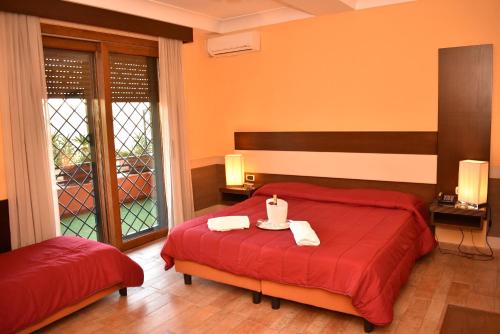 a bedroom with a red bed with two towels on it at Hotel Miravalle in Naples