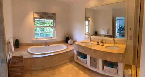 łazienka z 2 umywalkami i dużym lustrem w obiekcie Battaleys Mews w mieście Saint Peter