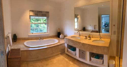 a bathroom with two sinks and a large mirror at Battaleys Mews in Saint Peter