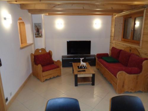 salon z 2 kanapami i telewizorem w obiekcie La Bartavelle w mieście La Giettaz