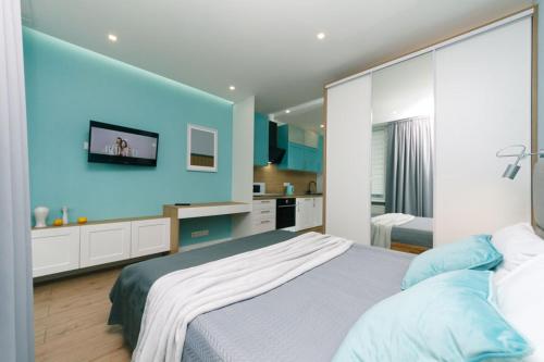 a bedroom with a large bed and a blue wall at Happy apartment, warmth, comfort, turquoise in Kyiv
