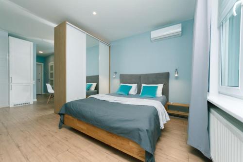 ein Schlafzimmer mit einem großen Bett mit blauen Kissen in der Unterkunft Happy apartment, warmth, comfort, turquoise in Kiew