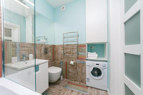 ein Badezimmer mit einer Waschmaschine und einem Waschbecken in der Unterkunft Happy apartment, warmth, comfort, turquoise in Kiew