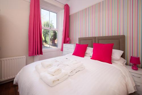 a bedroom with a bed with white sheets and red pillows at Manor House - Hot Tub House for max 10 people in Birtley