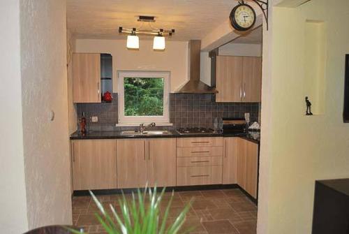 a kitchen with a sink and a clock on the wall at DOMEK NA BASZCIE klimatyzowany in Lesko