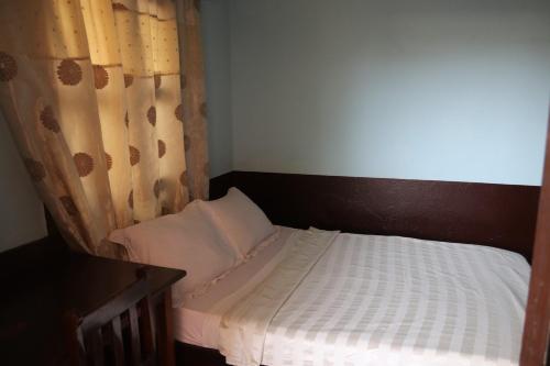 a small bedroom with a bed with a curtain at Hotel Aurore Lomé in Lomé