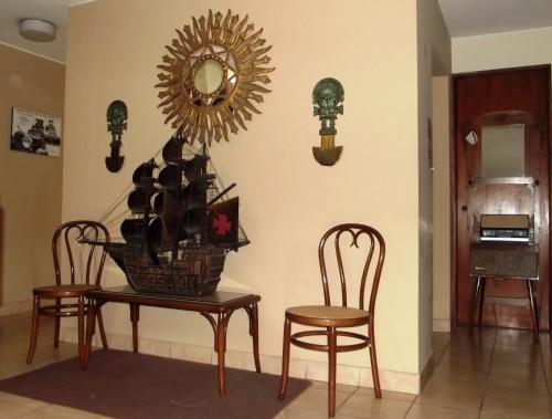 a table and two chairs and a mirror on a wall at Hostal Gemina in Lima