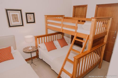 1 dormitorio con 2 literas y sofá en Pousada Villa D'Ouro, en Penha