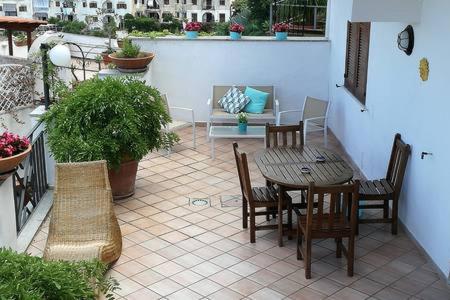 un patio con mesa, sillas y sofá en "CASA SUNSET" en Ischia