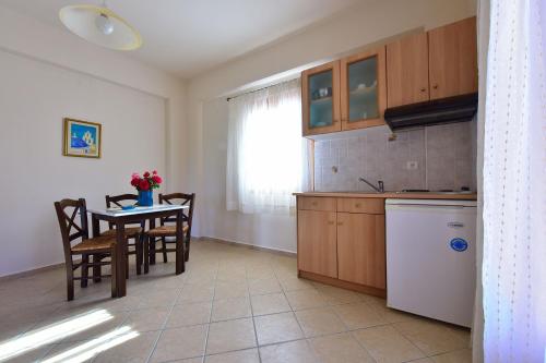 a kitchen and dining room with a table and a table and chairs at So Nice Hotel in Marathokampos