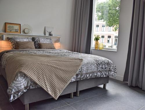 Un dormitorio con una cama grande y una ventana en "In de Kloosterhof" Gratis privé parkeren, en Assen