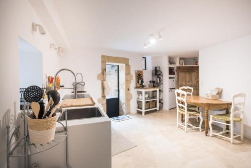- une cuisine avec un évier et une table dans l'établissement Le Patio du Mûrier, à Vers-Pont-du-Gard