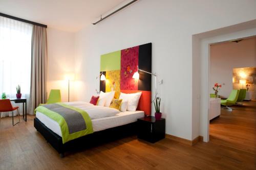 a bedroom with a bed with a colorful headboard at Vienna House by Wyndham Andel's Lodz in Łódź