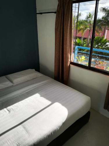two beds in a room with a window at TEMPO in Semporna