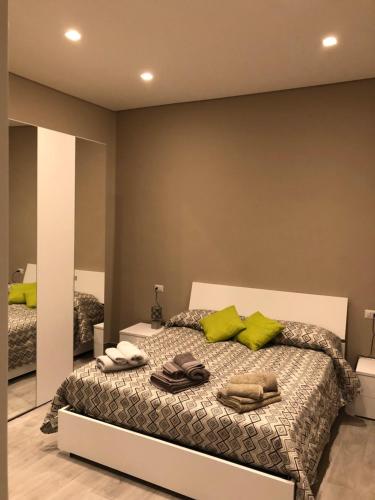una camera da letto con letto, cuscini verdi e specchio di il Loft a Cuneo