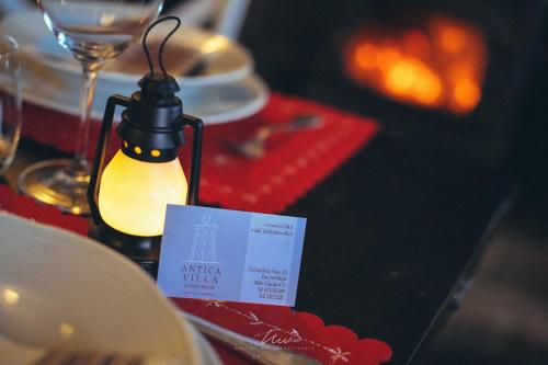 a table with a light on a table with plates and glasses at ANTICA VILLA CUNEO- Guest House - "B&B e non un Hotel a Cuneo" in Cuneo