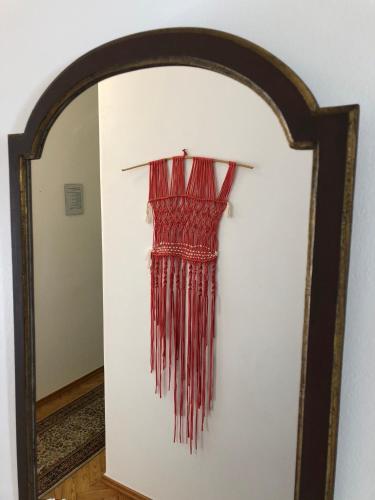 a red dress hanging on a wall in a mirror at Lines of Wellignton in Torres Vedras
