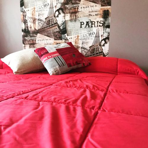 a red bed with a red comforter and a pillow at Il Pozzo Country House in Collescipoli