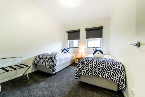 a bedroom with two beds and a window at Leven River Retreat in Ulverstone